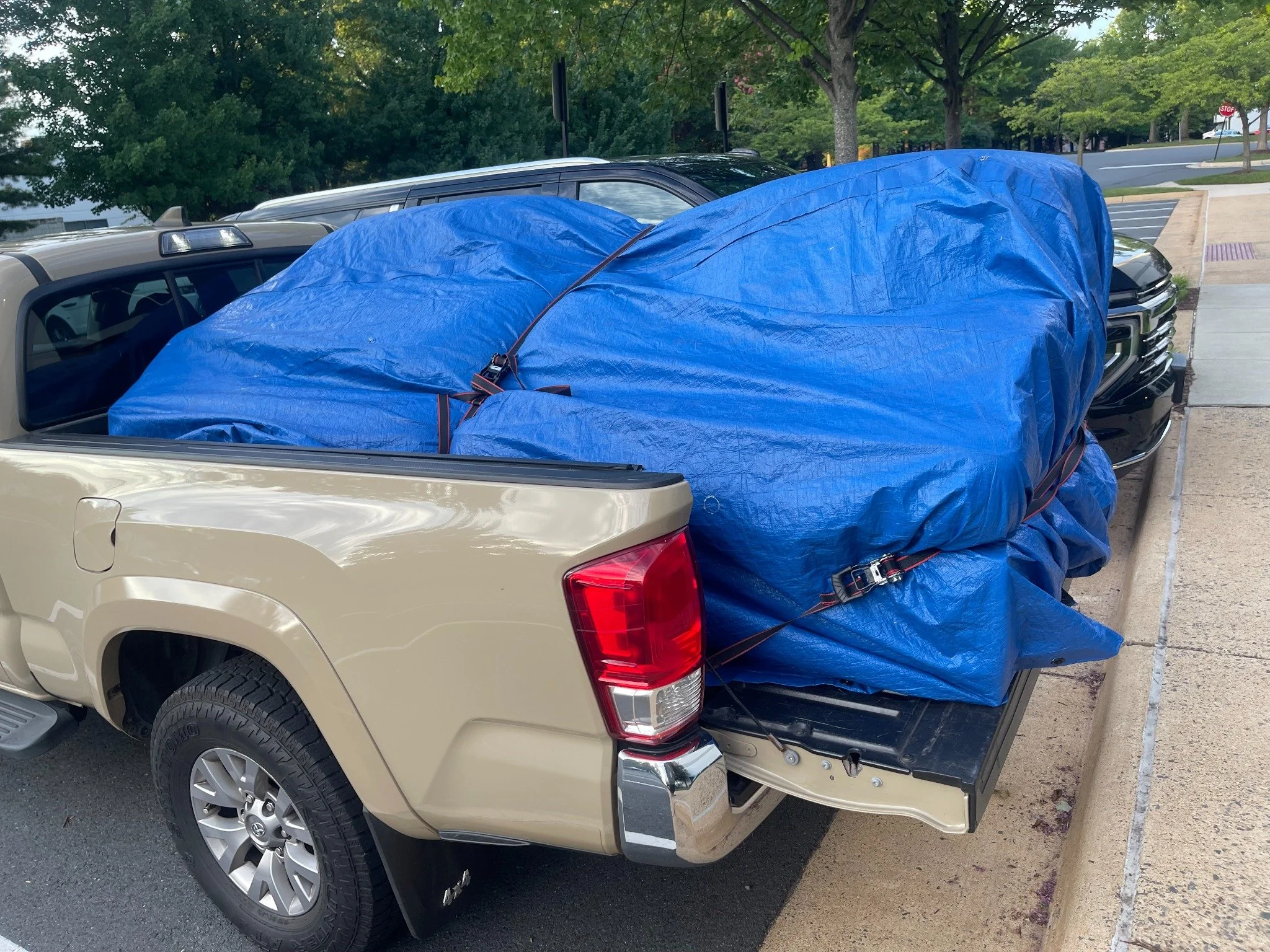 Ashburn couch donation pickup — couch covered with a blue tarp and secured for transport.