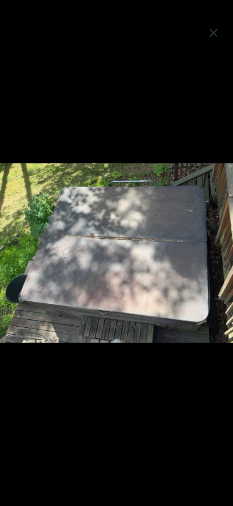 Hot tub removal — before, showing the covered tub from above.