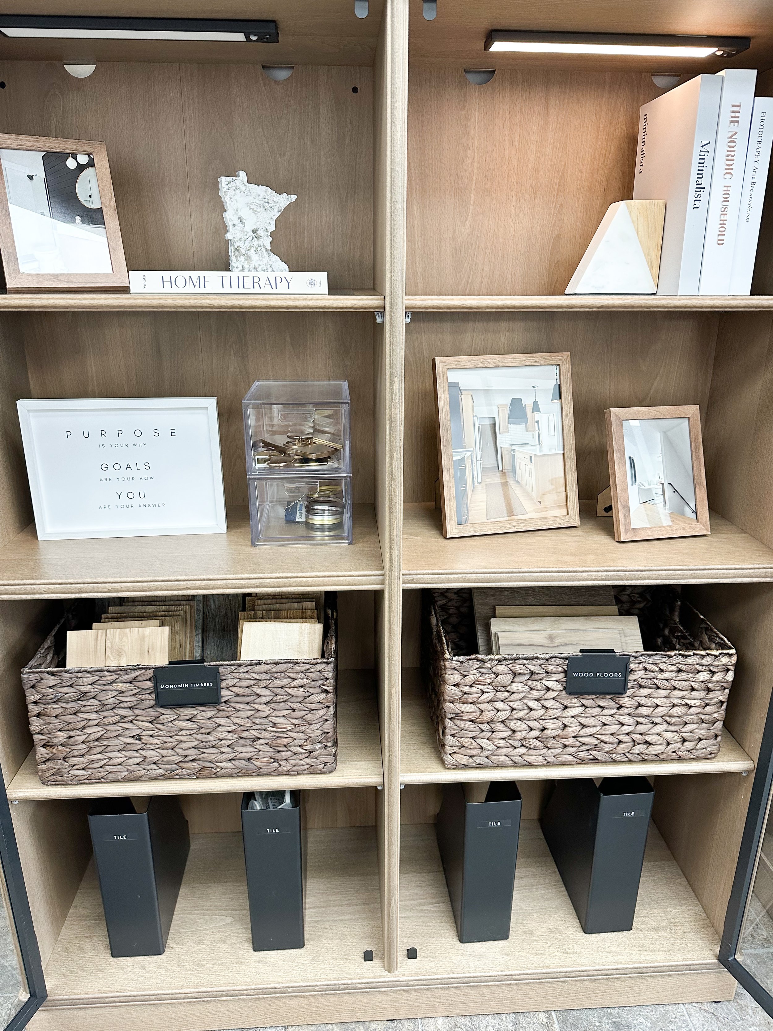 Display shelf with home decor items, photo frames, books, wood samples, and storage boxes.