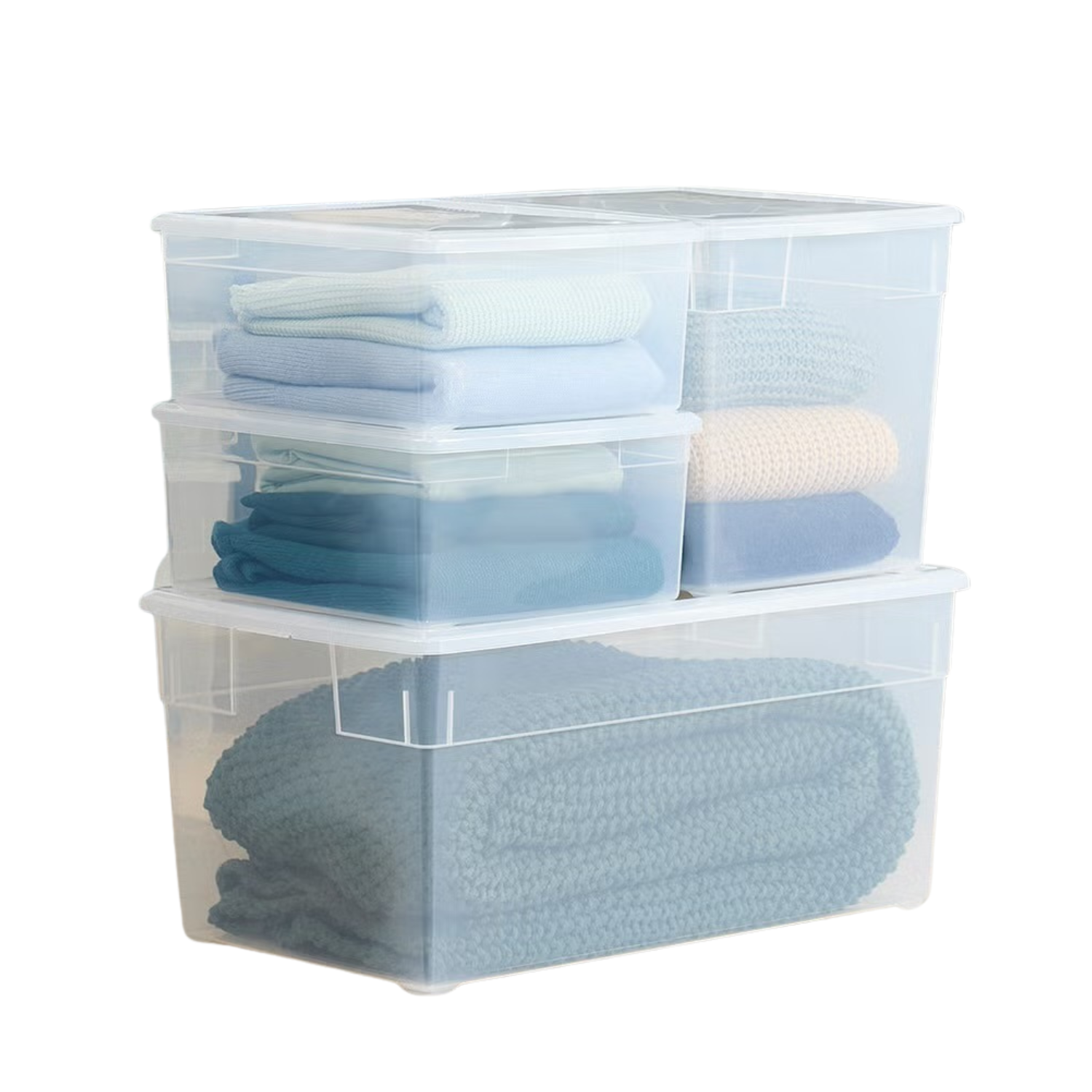 Stacked transparent plastic storage containers filled with folded blankets and towels.