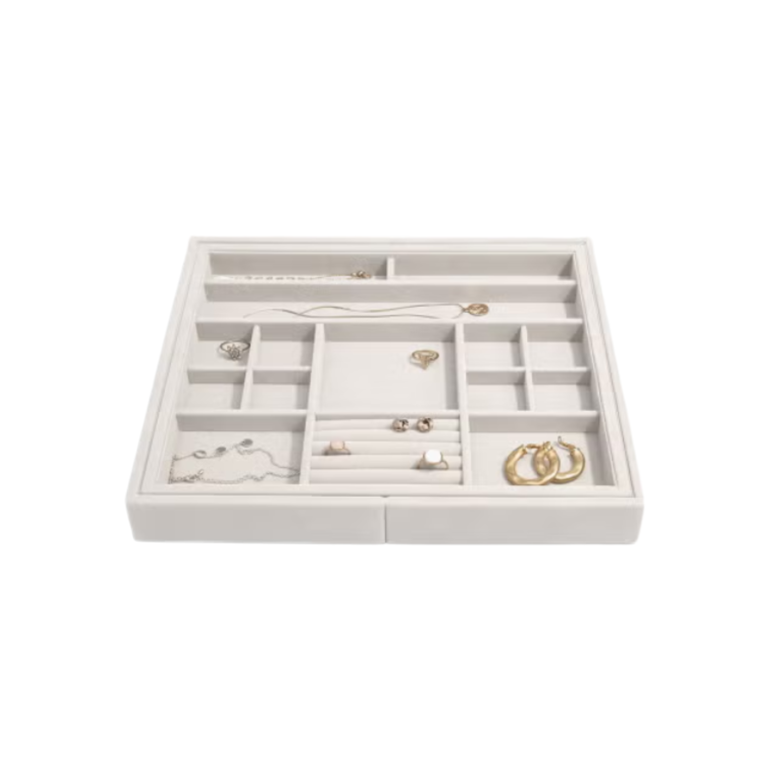 White jewelry organizer drawer with various necklaces and earrings inside.