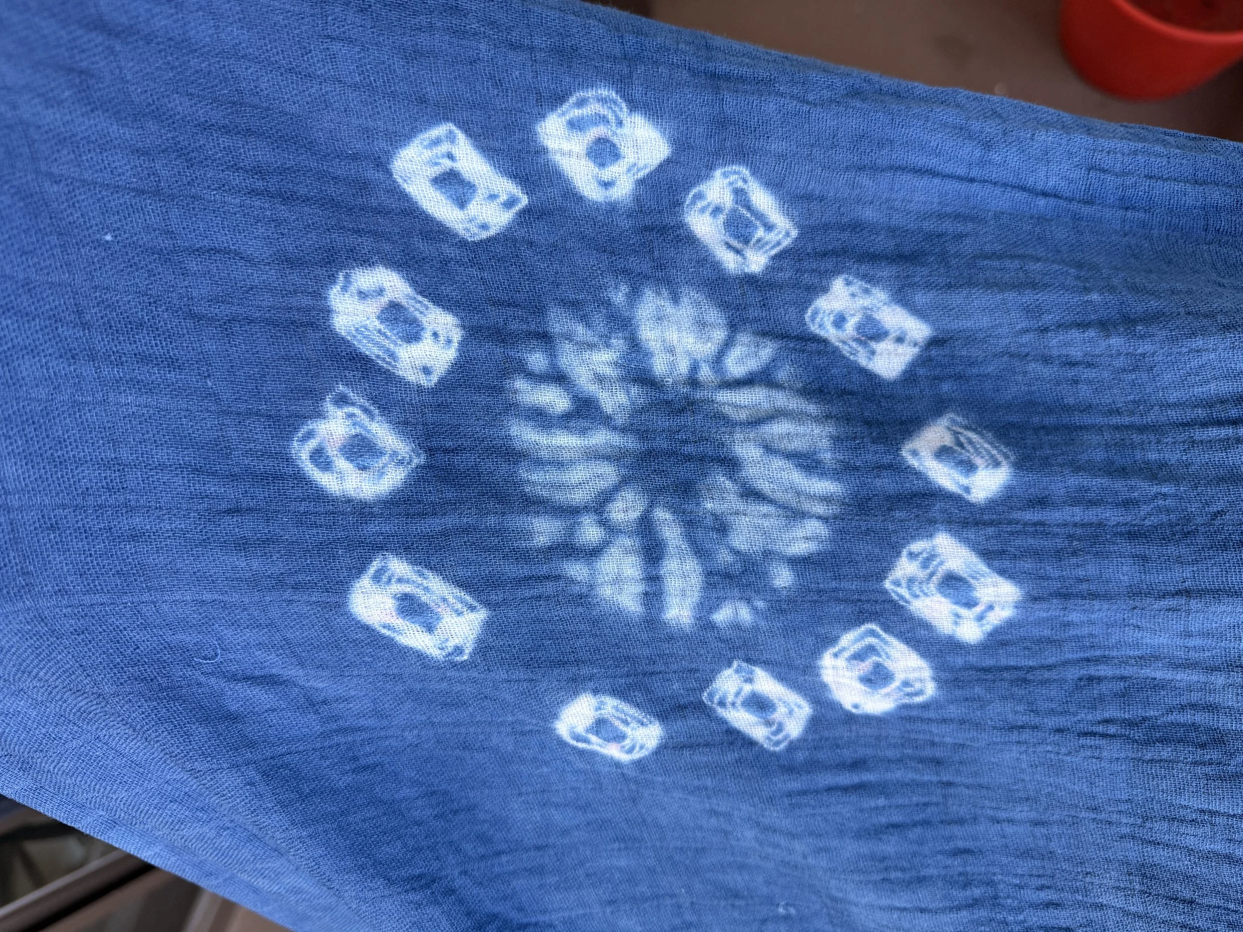 Detail of a smaller resist circle, surrounded by twelve white squares.  The squares were  from beads tied in the fabric to create a small resist.