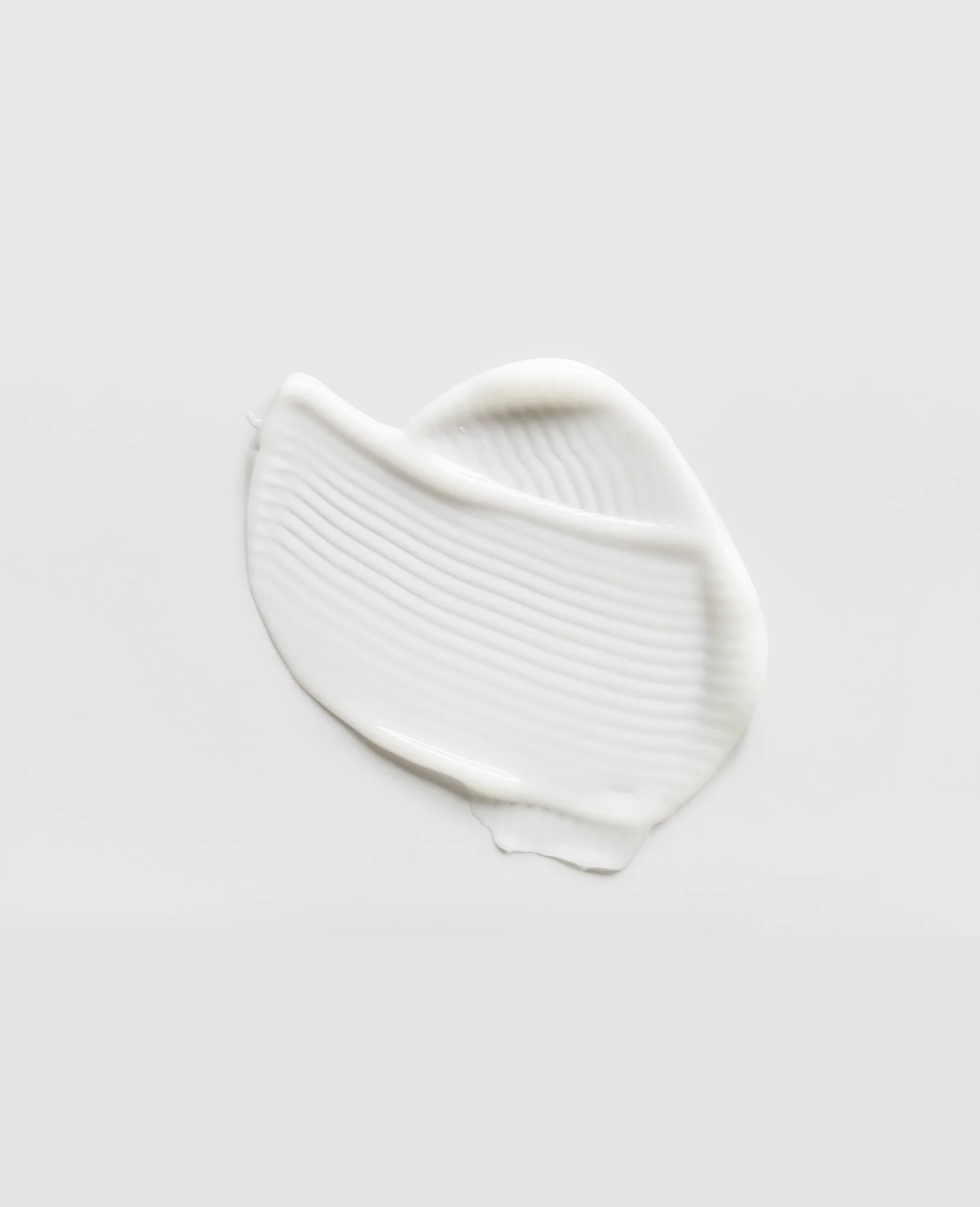 A dollop of white cream or lotion with a smooth, textured surface on a plain white background.