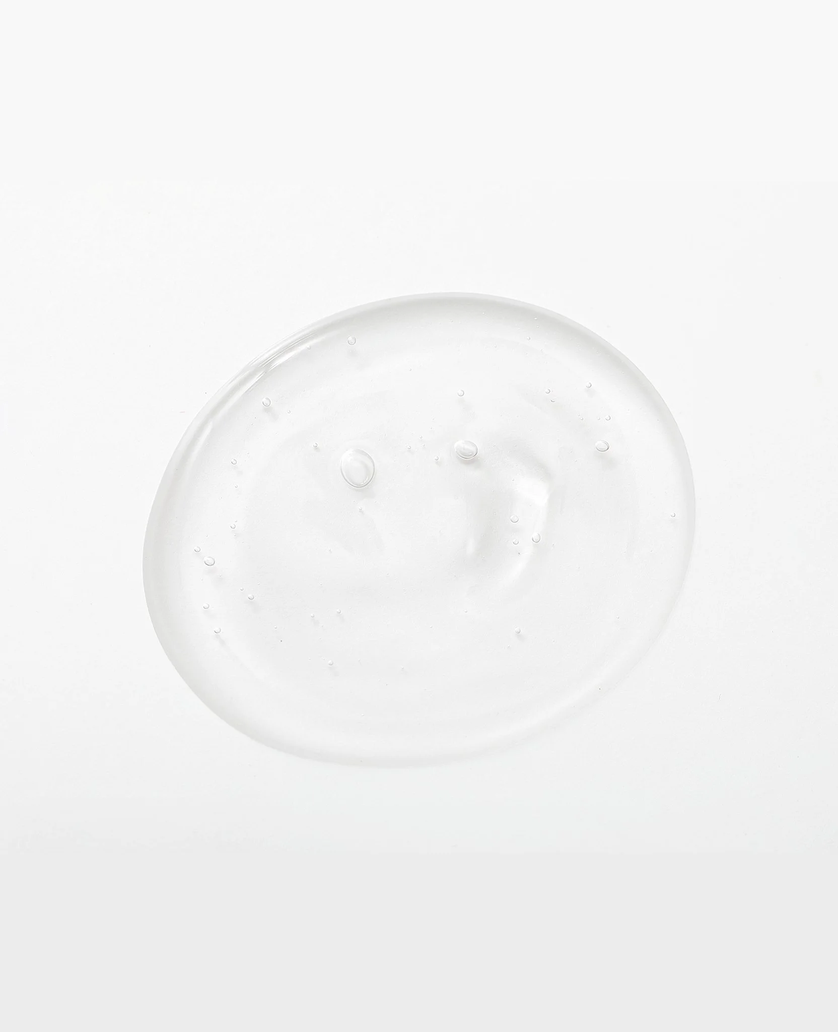 A clear, round gel or liquid substance with bubbles inside on a white background.