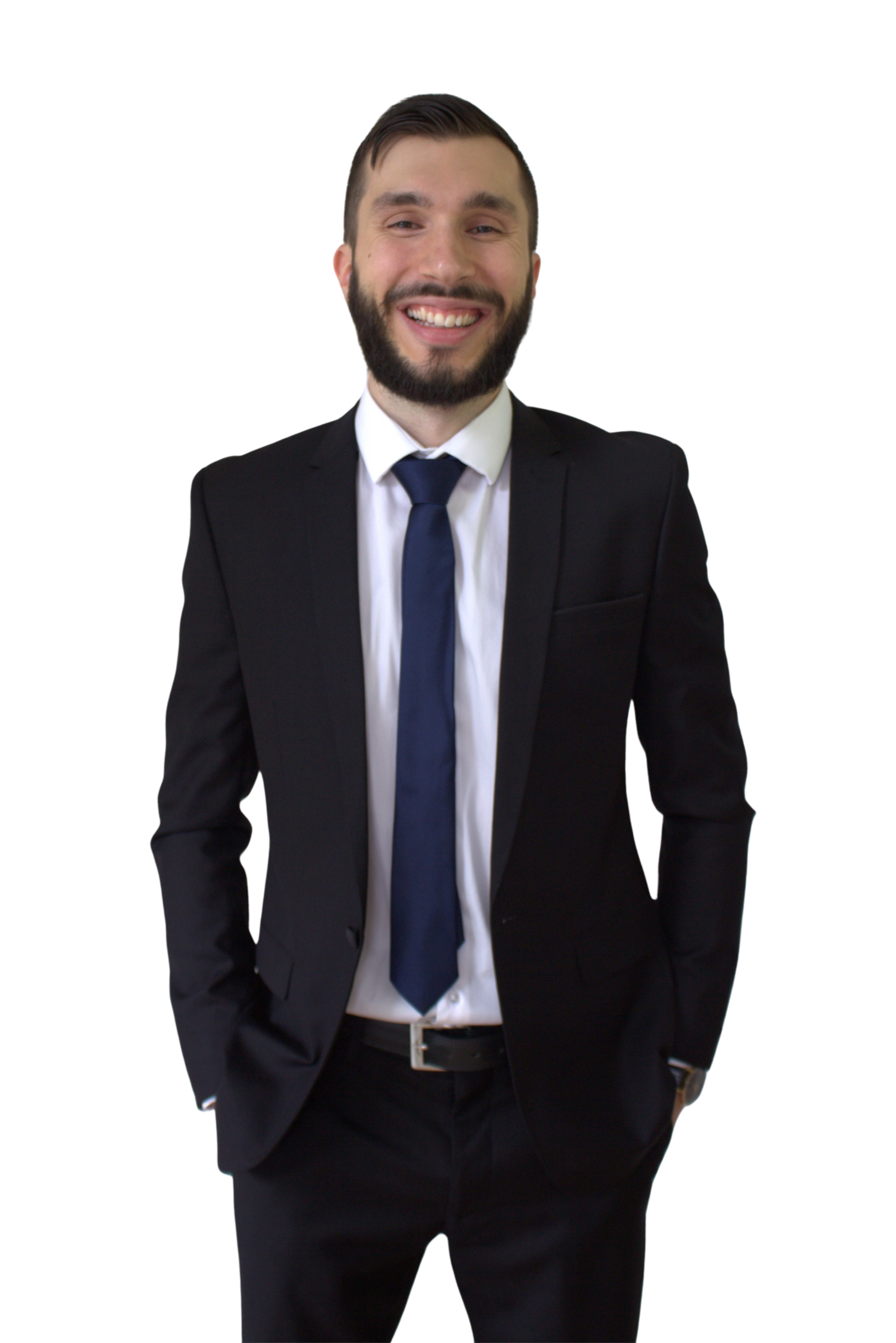A man in a black suit, white shirt, and navy blue tie smiling with hands in his pockets.