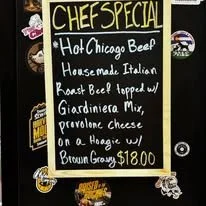 Cheat street chalkboard menu advertising a chef special: hot Chicago beef with housemade Italian roast beef, topped with Giardiniera mix and provolone cheese on a hoagie with a brown gravy for $12.80.