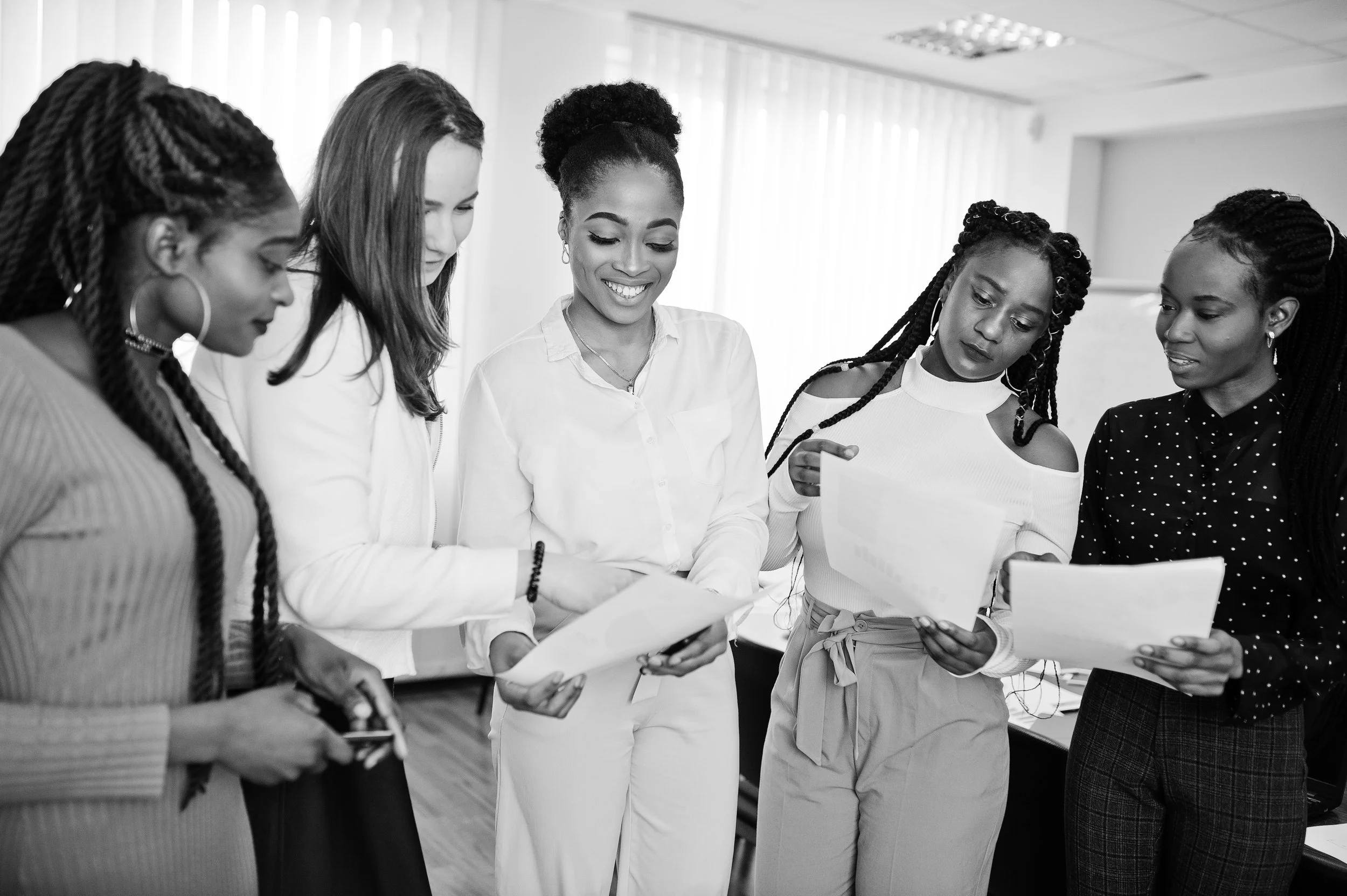 five-multiracial-business-womans-standing-office-with-papers-hands-diverse-group-female-employees