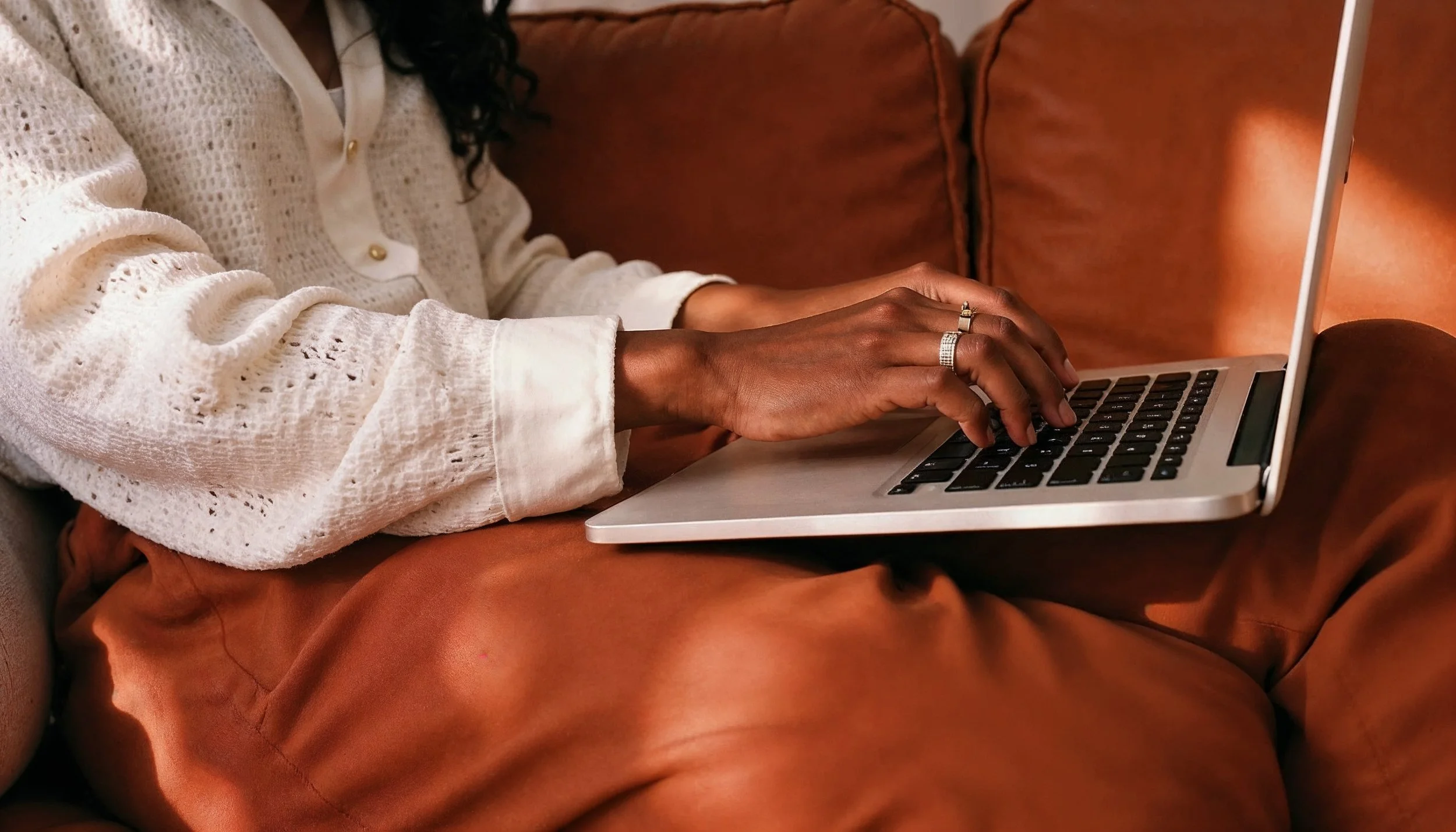 woman-typing-laptop-warmcolored-environment.