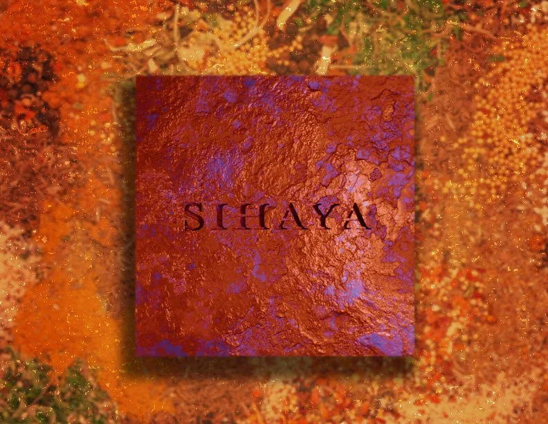 A red textured box with the word "SIHAYA" printed on it, placed on colorful, glittery, orange and gold surface.