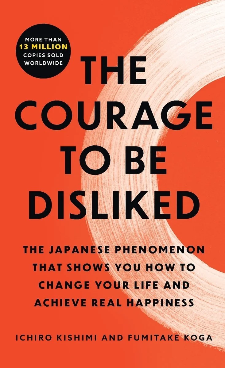 Book cover titled "The Courage to Be Disliked" with an orange background and a white curved brushstroke. Text highlights that over 13 million copies were sold worldwide. Authors are Ichiro Kishimi and Fumitake Koga, and it describes the book as about a Japanese phenomenon that teaches how to change your life and find happiness.