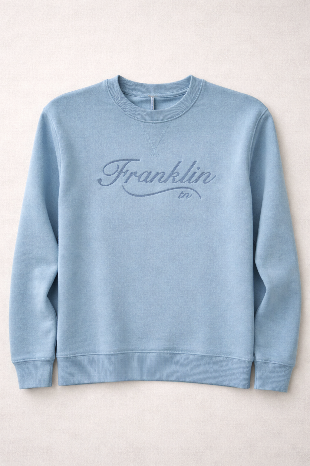 A light blue crewneck sweatshirt with 'Franklin tn' embroidered on the front in cursive script.