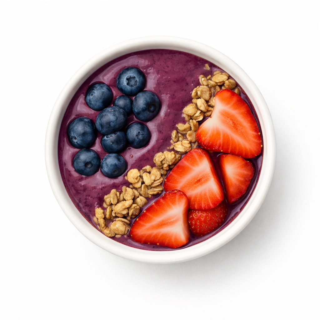 A bowl of smoothie topped with blueberries, sliced strawberries, granola, and a red berry.