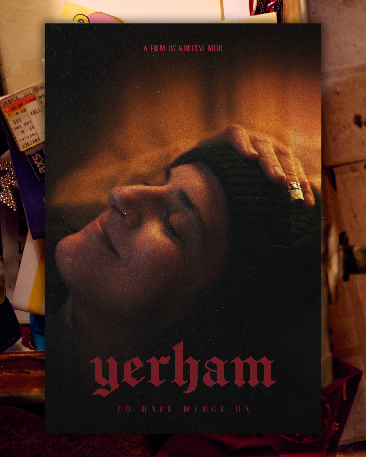 A woman with closed eyes, wearing a beanie, resting her head with her hand on her forehead. The background is dark with warm lighting. The text on the cover reads 'Yerham' and 'To Have Mercy On,' with a film credit to Khitam Jabr at the top.