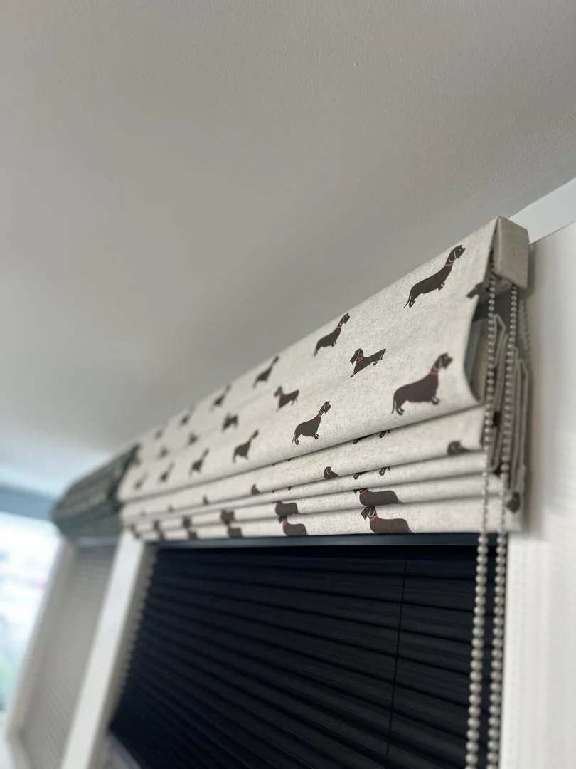 Window valance with a dachshund dog pattern and black blinds below, near a ceiling
