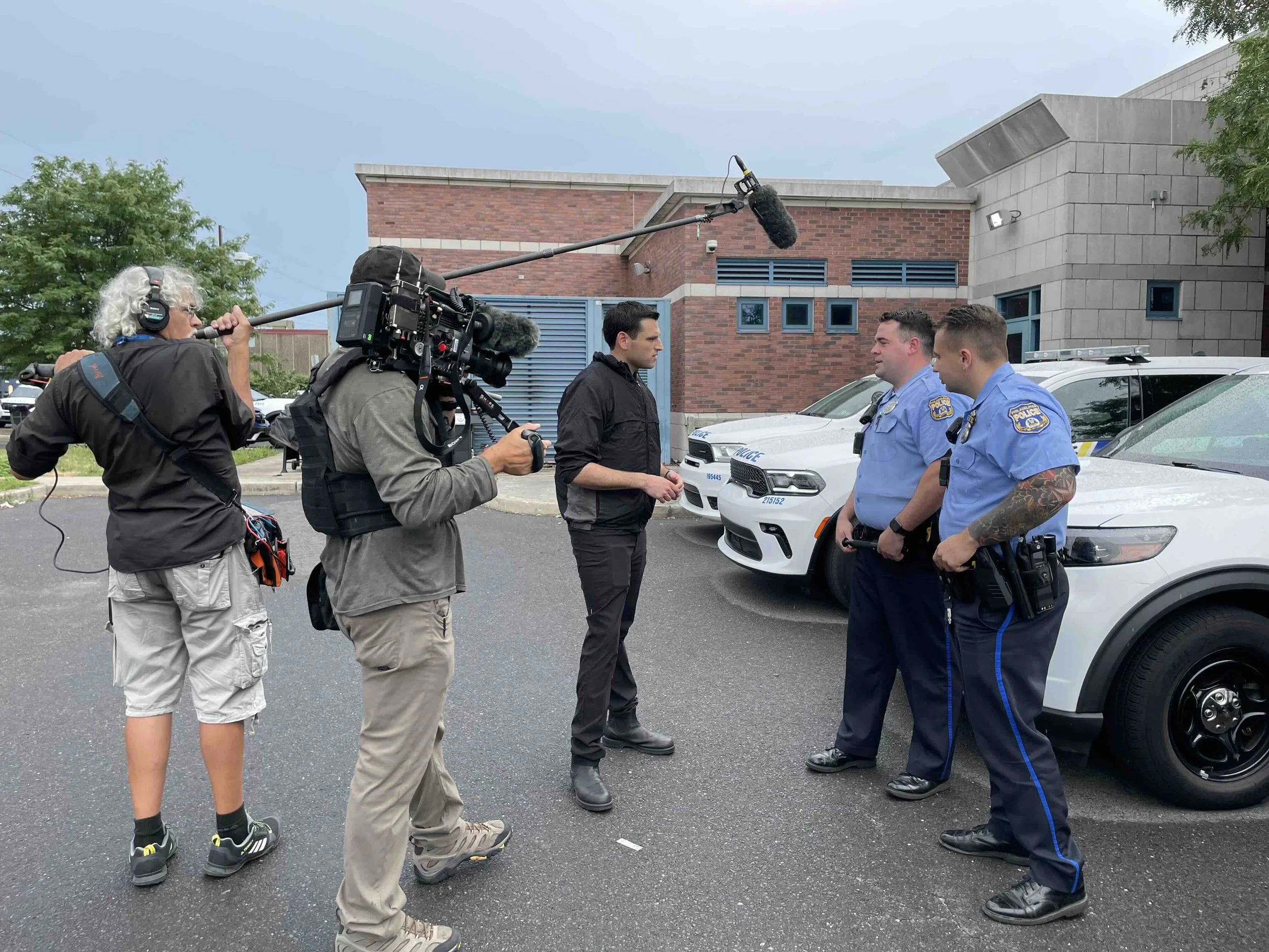 Philadelphia, PA  Jesse Kirsch conducts an interview with two  officers outside the station, before a nightly ride-along with police.