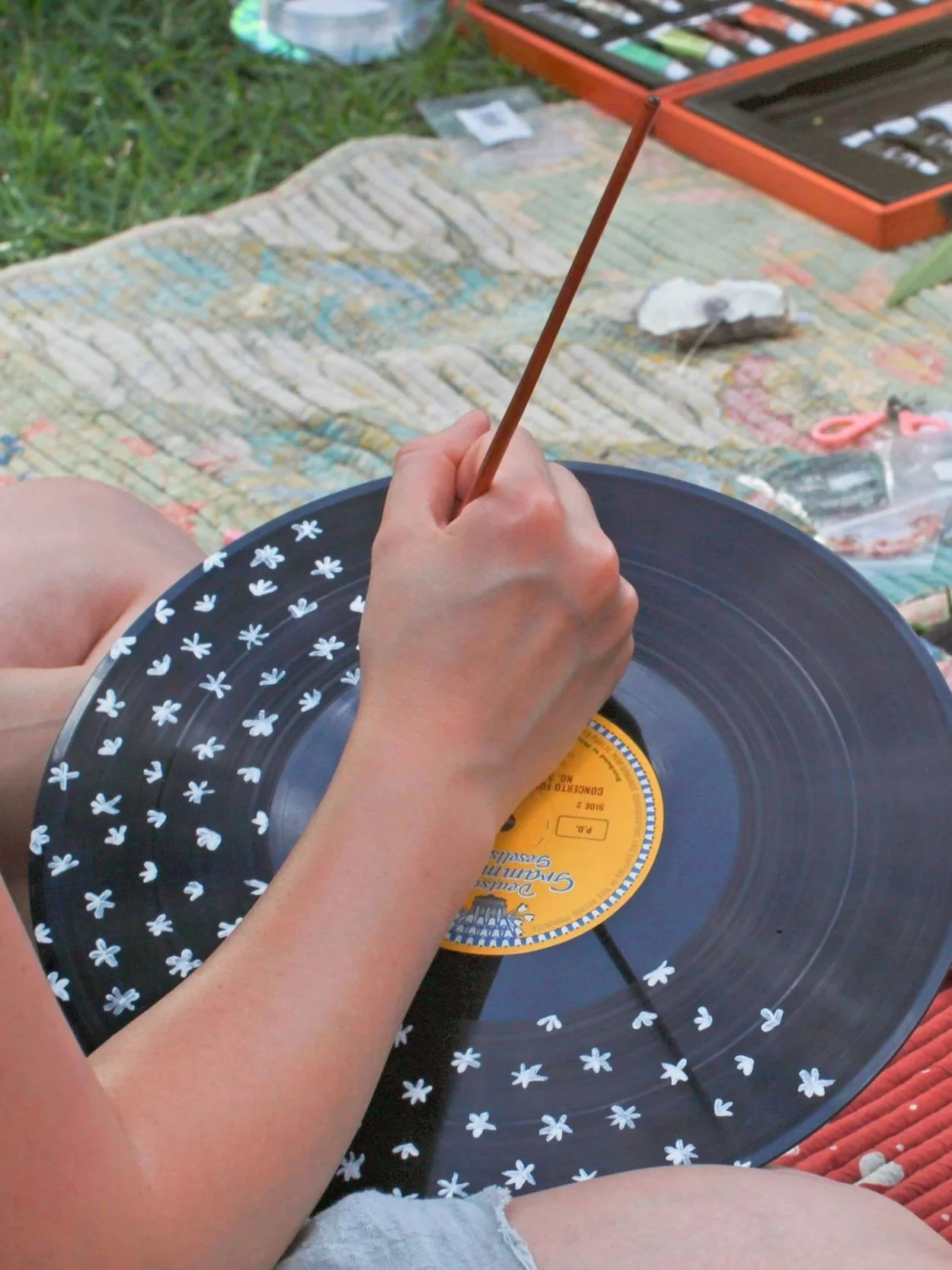 Daisies being painted on a vinyl record during a workshop