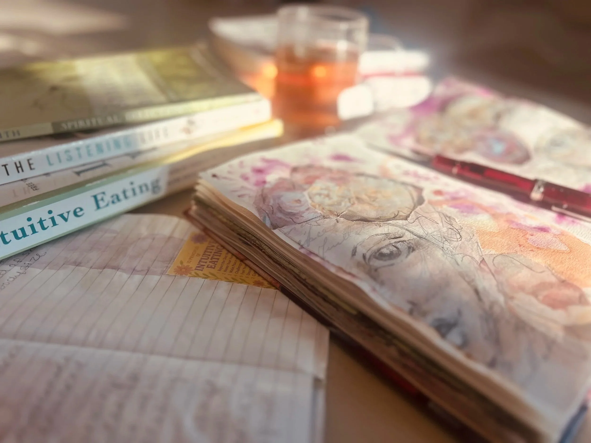 Close-up of currency bills, a glass of liquid, and a notebook with handwritten notes.