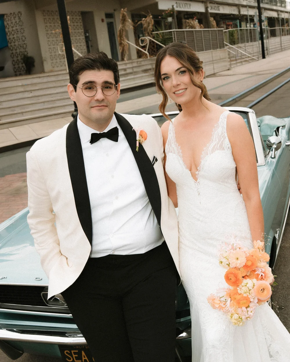 Bride and groom beside a vintage car