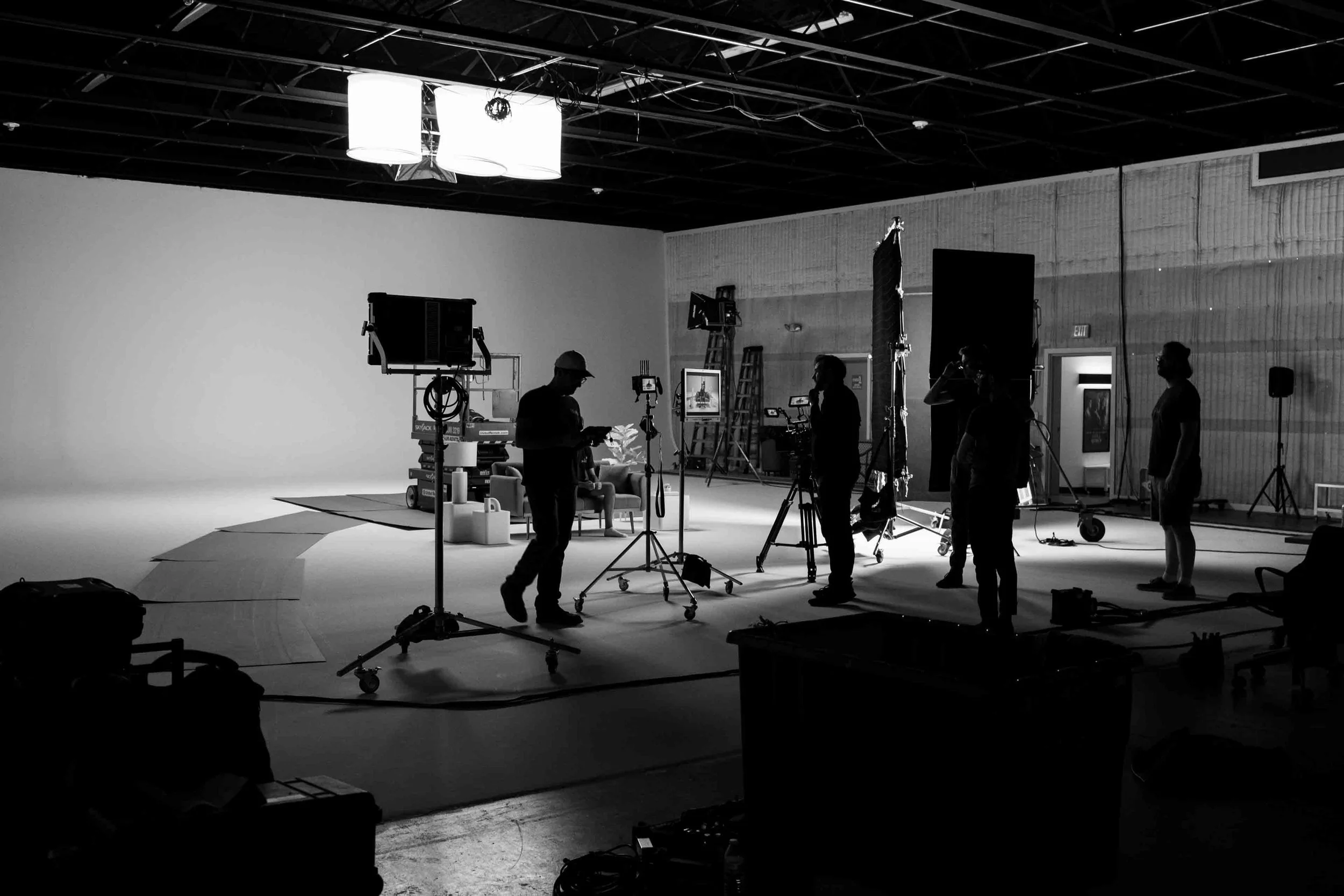 The video production crew setting up equipment for a corporate shoot in a white cyc studio
