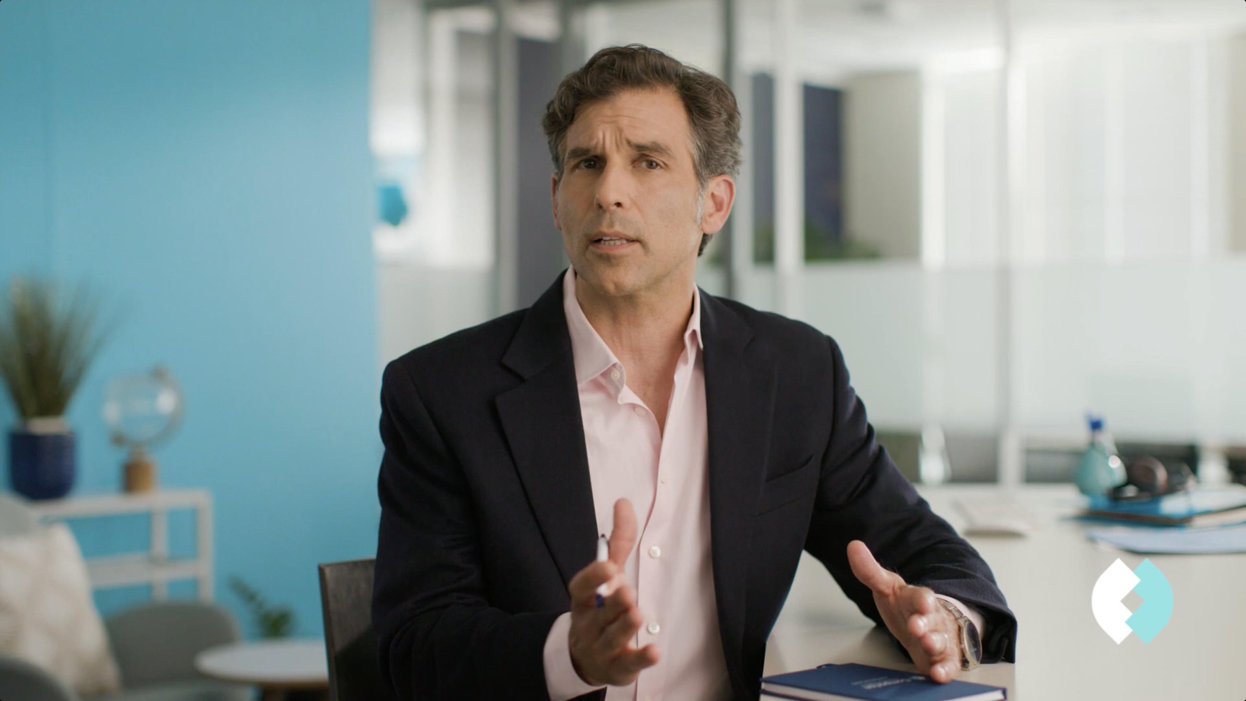 A man speaking directly to camera in a corporate office in this commercial recruiting video for Comparion