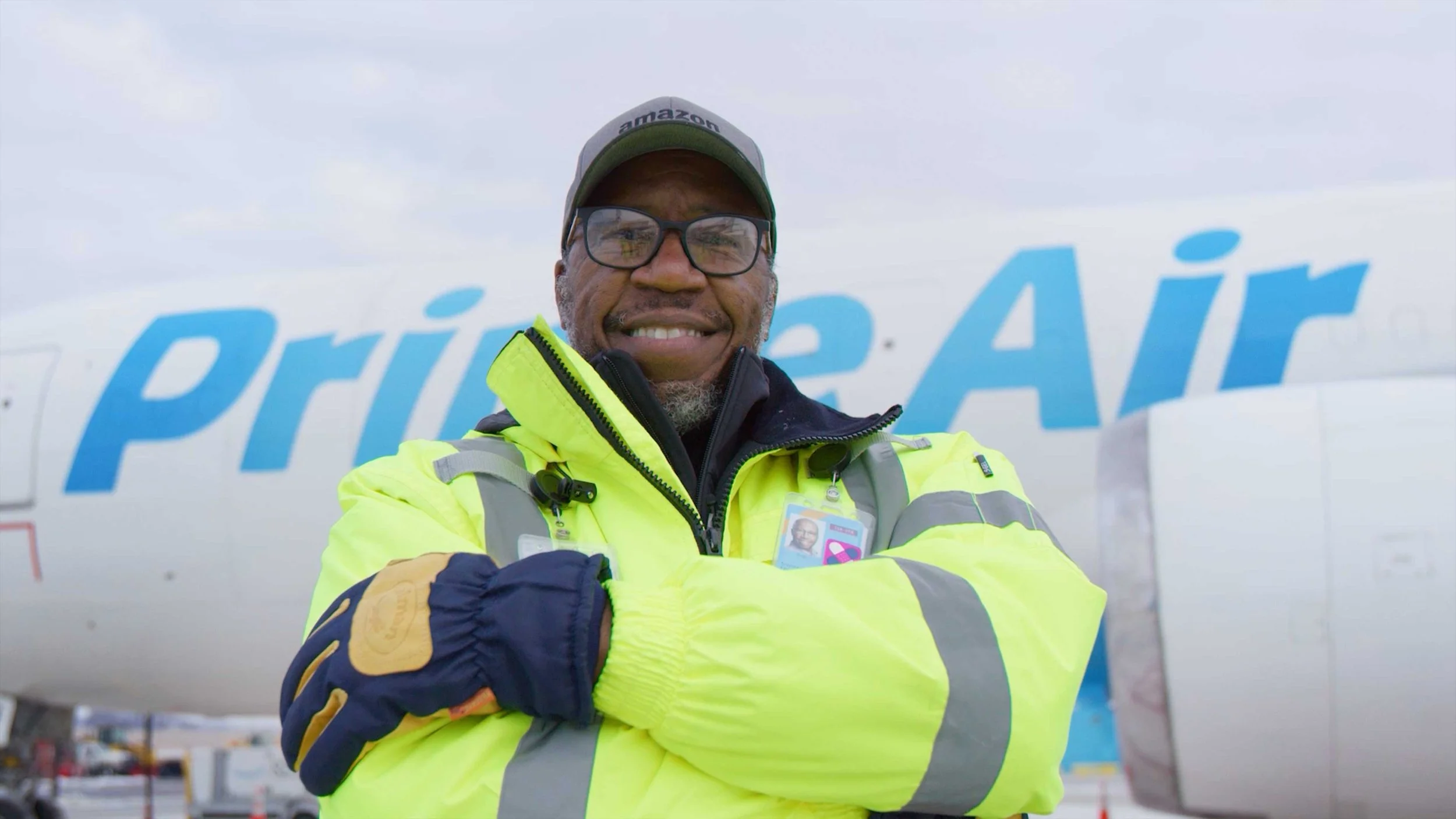 Amazon Air Hub employee stands with arms crossed in front of Prime plane in the Chart Your Path doc-style video