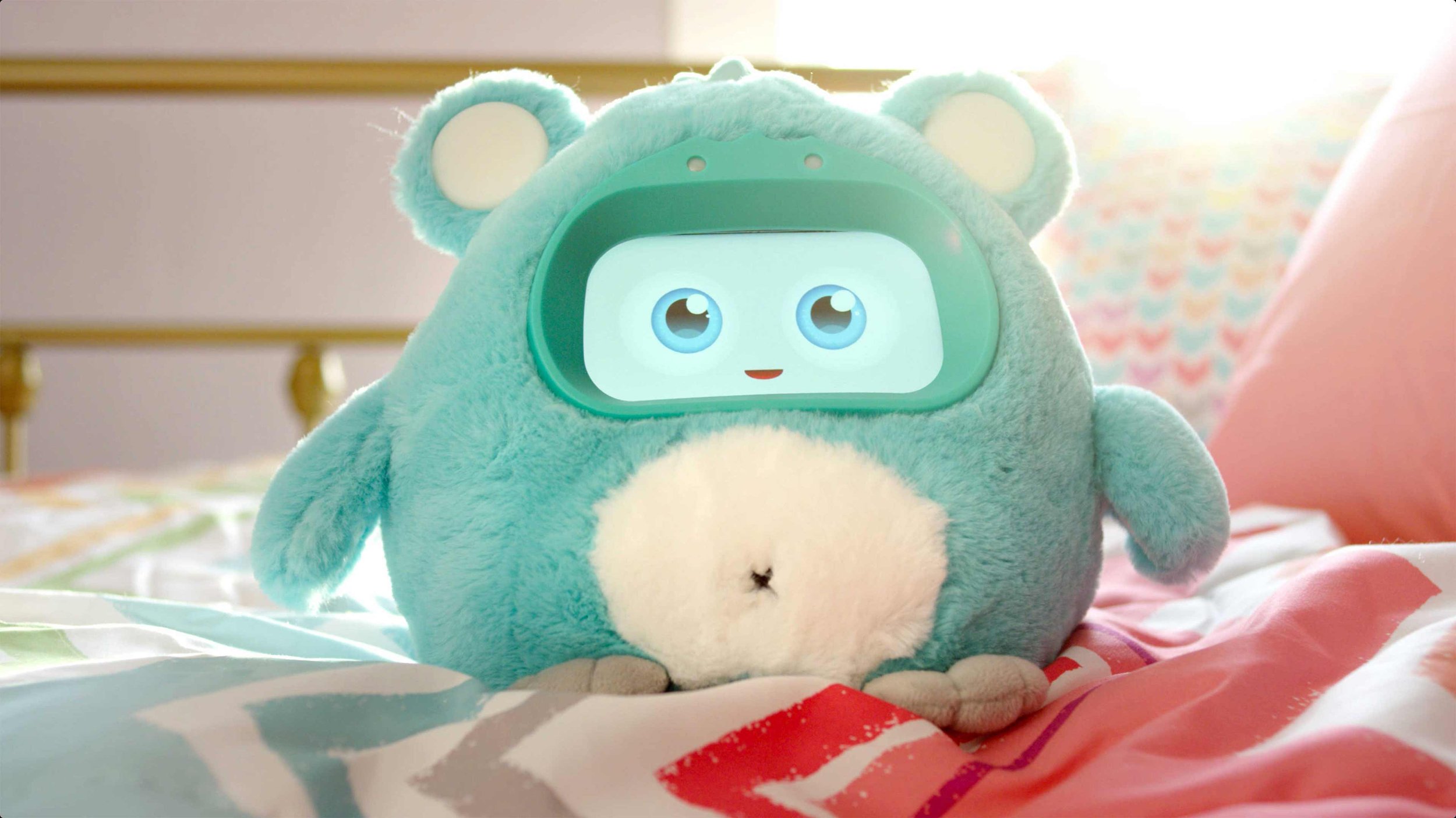 A furry kids toy named Woobo with a digital screen for a face on a warm bright bedroom in a commercial product video