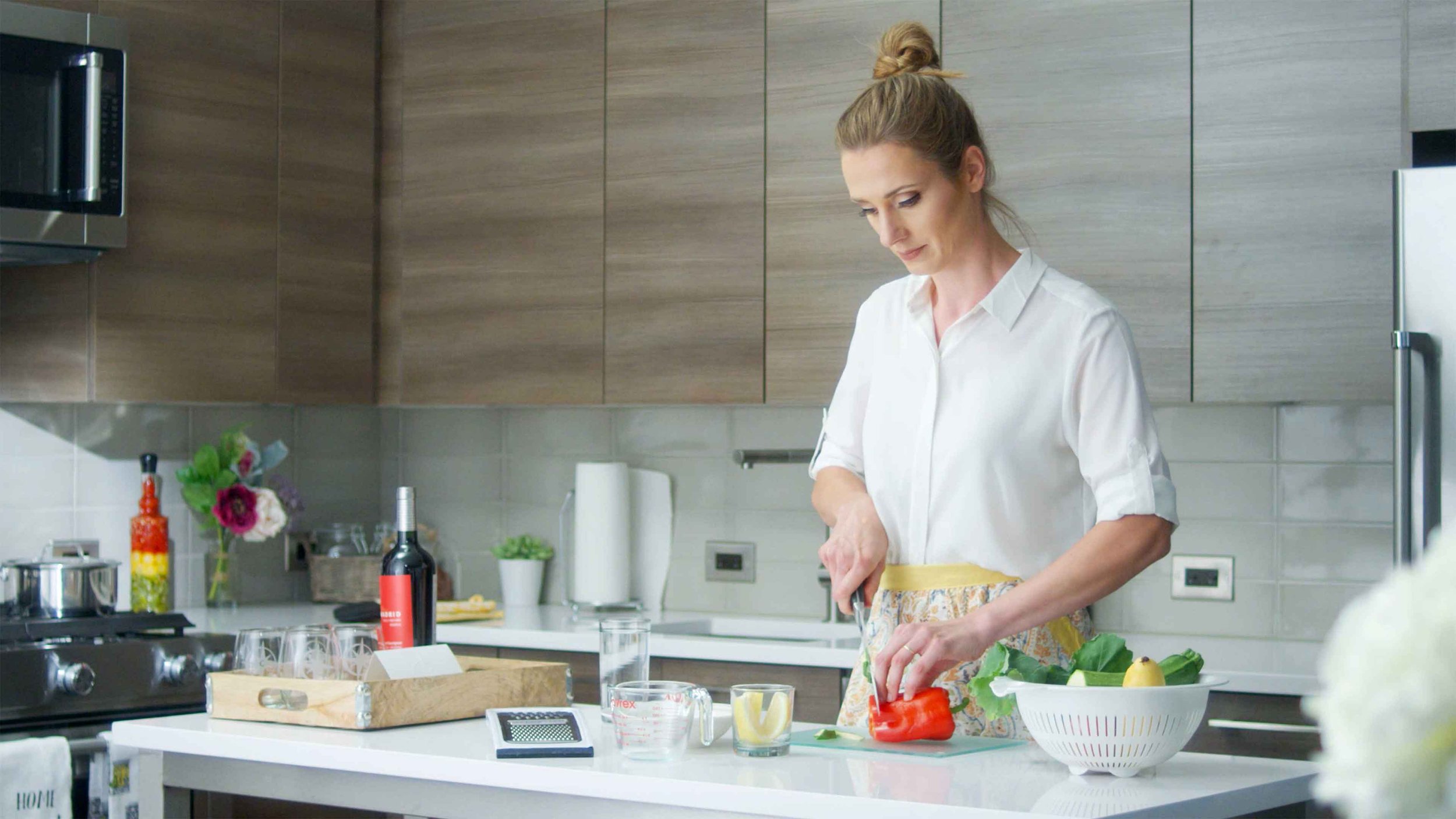 A woman cuts vegetables as she prepares dinner in her home away from home
