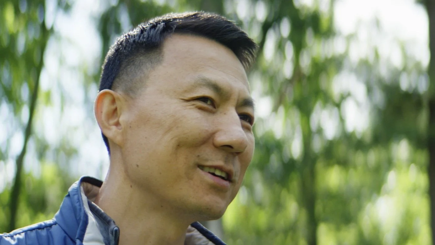 A man smiles in an outdoor setting in a patient testimonial video for Thermo Fisher Scientific