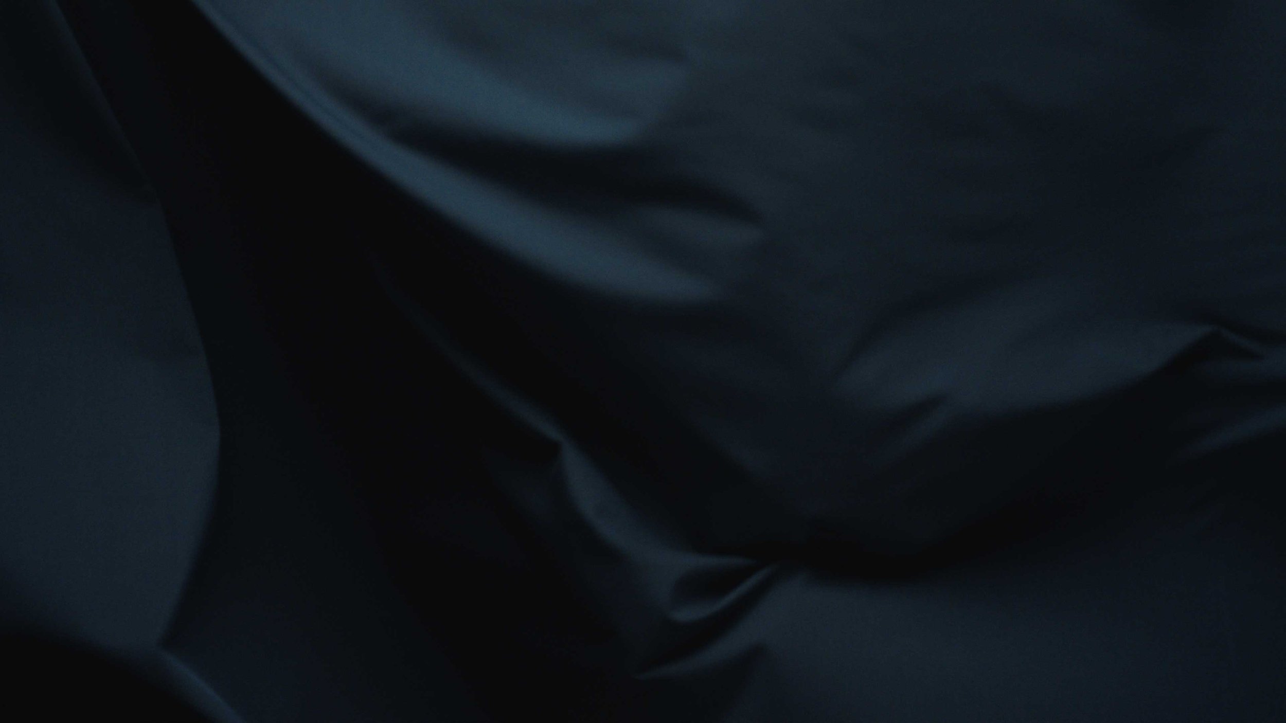 A navy fabric rustles in the air in a clothing brand product video