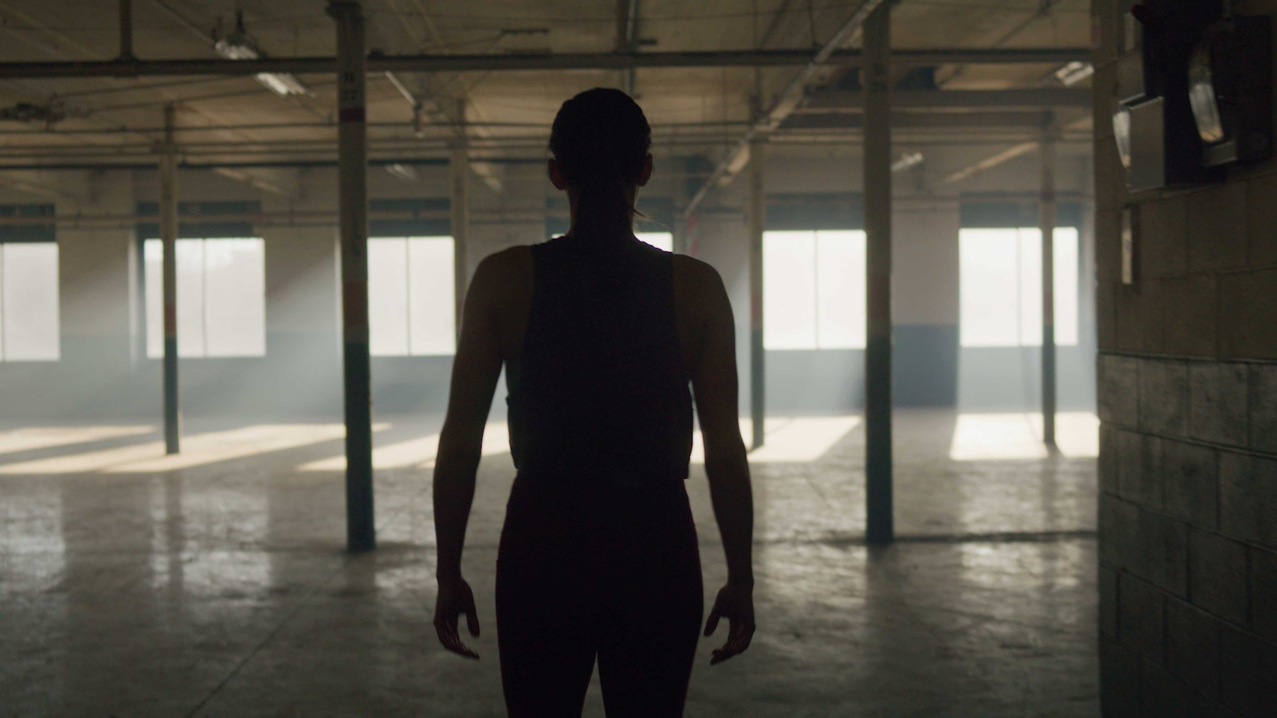 Athlete walking through industrial gym space during sports training shoot