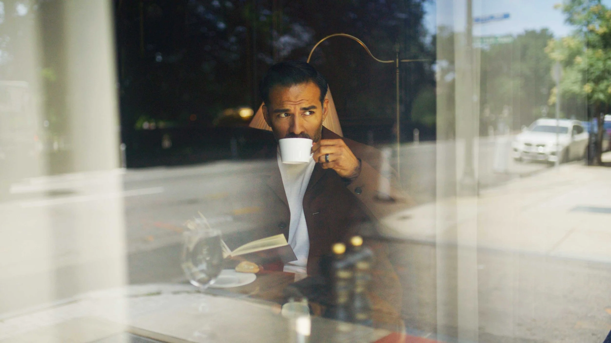 A man sipping coffee at a hotel cafe for a commercial video