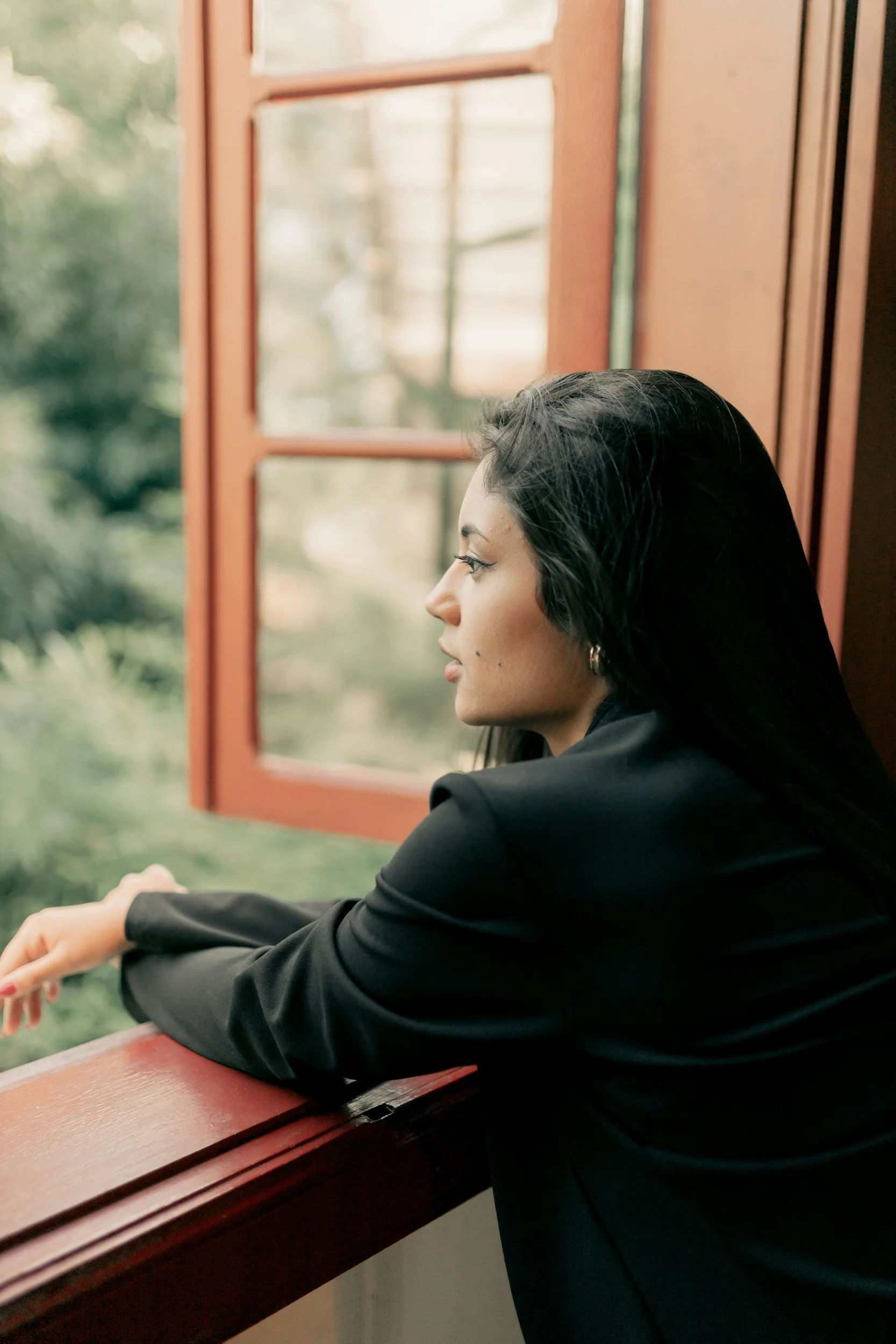 lady looking out the window to depict introspection and letting go after going through therapy for anxiety