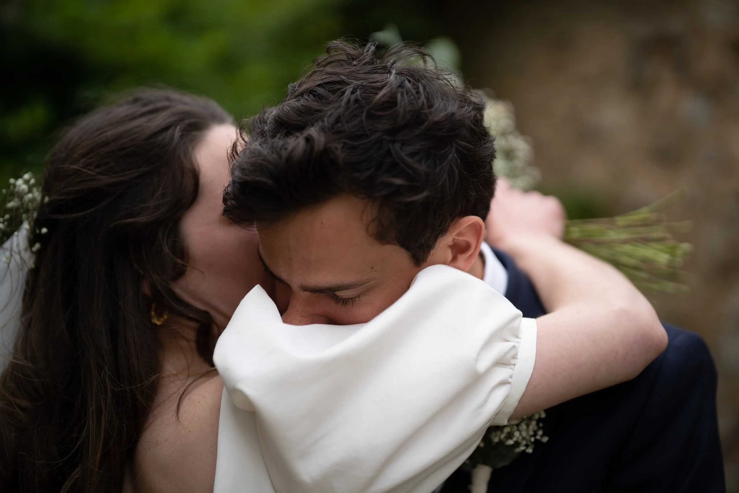 Deux personnes, un homme et une femme, en train de s'étreindre et de partager un moment intime en extérieur.