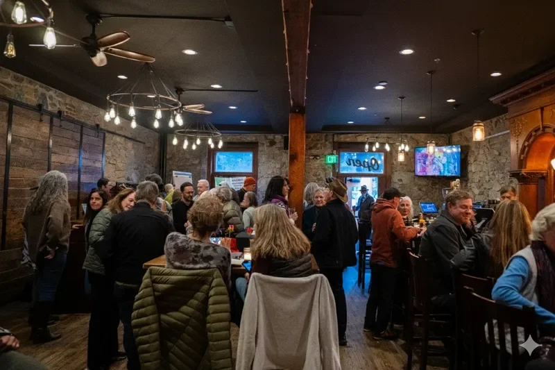 People socializing in a cozy bar with stone walls, wooden furniture, and warm lighting.