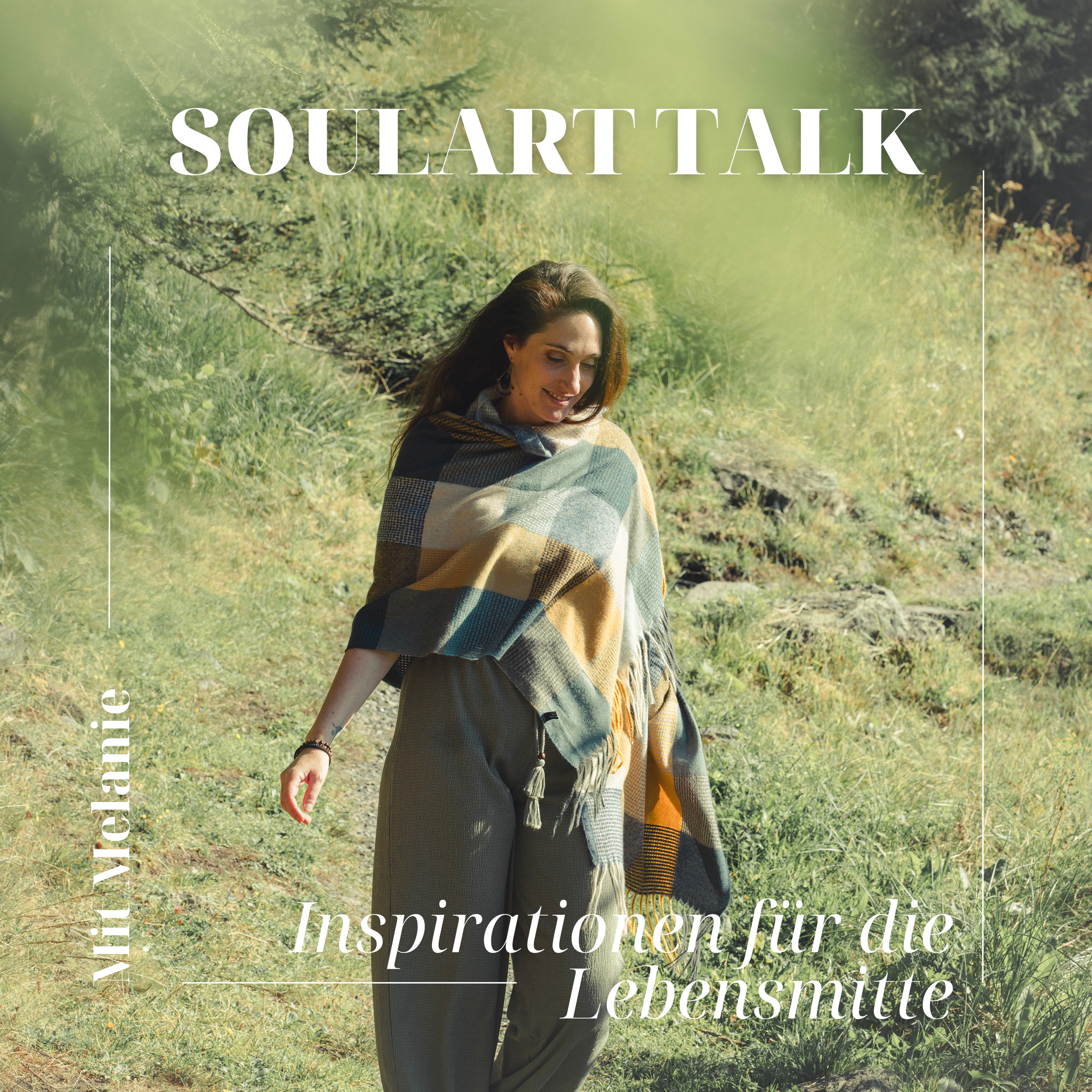 Ein T-Shirt mit dem Titel 'SoulArtTalk', ein Vortrags- oder Workshop-Event. Das Bild zeigt eine lächelnde Frau im Freien, eingehüllt in einen karierten Schal, in einer grünen, sonnigen Landschaft.