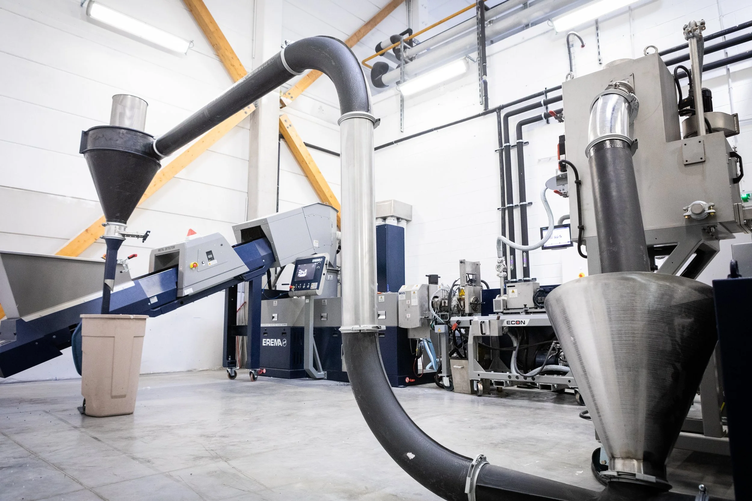 Industrial machinery with tubing and controls in a clean, well-lit factory or processing plant.