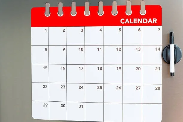 A blank desk calendar with a red header labeled 'CALENDAR' and a black marker pen attached to the right side.