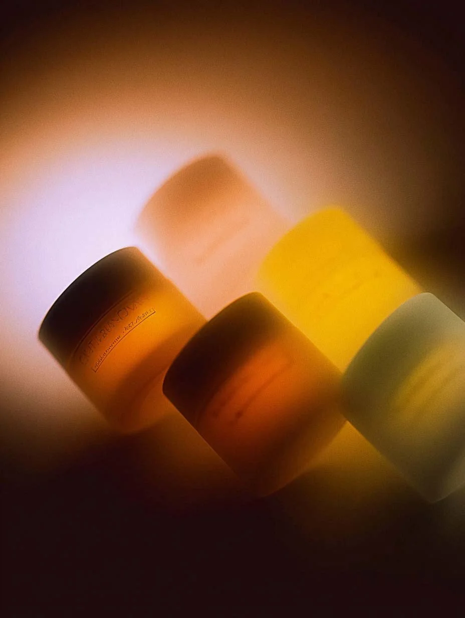 Quattro bottiglie di pillole di diversi colori illuminate da una luce calda