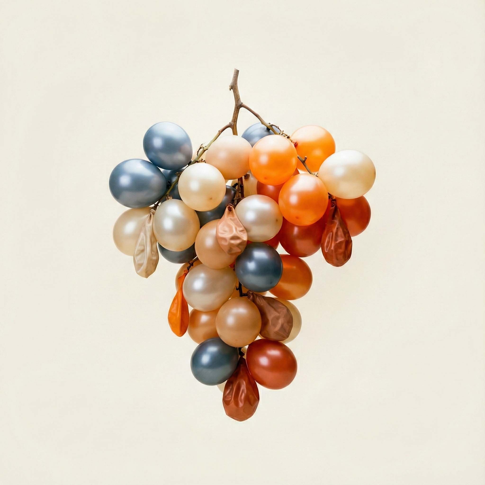 Un grappolo di uva decorativa realizzata con palloncini colorati e foglie di carta, sospeso in aria contro uno sfondo chiaro.