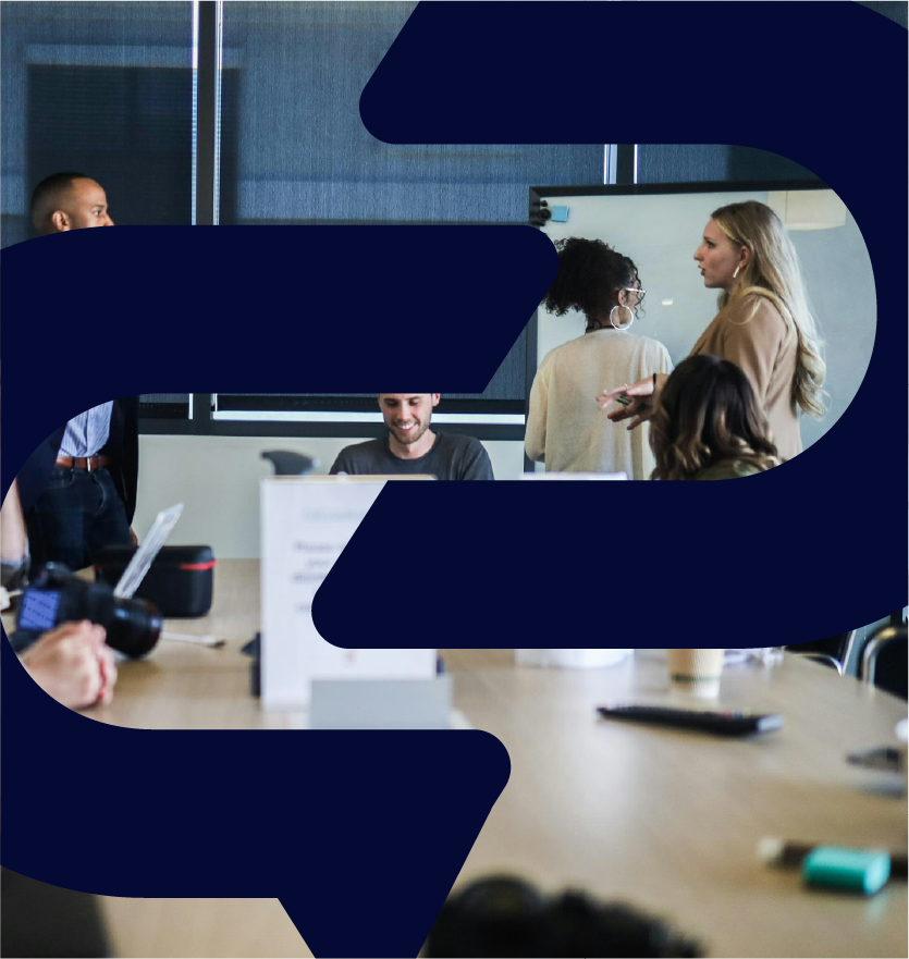 Groupe de personnes discutant dans une salle de réunion. Femmes et hommes échangent des idées autour d'une table.