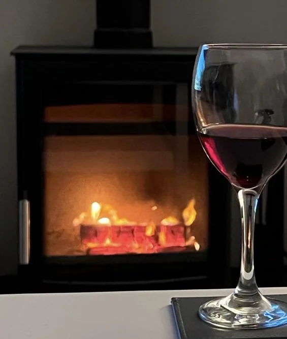 Drinking a glass of red wine on a table in front of a roaring fire in Cromer, North Norfolk