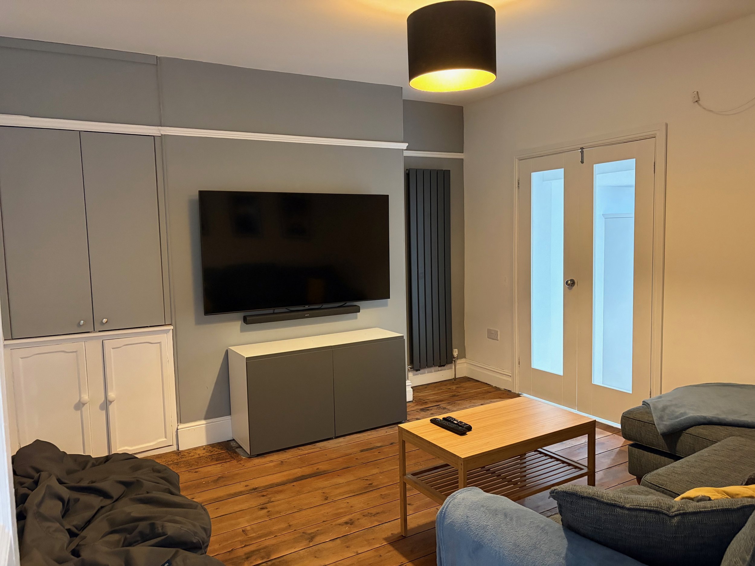 Coast House, Cromer, cinema room with a large flat-screen TV mounted on the wall, with large corner sofa and bean bags to snuggle up to watch that family film together