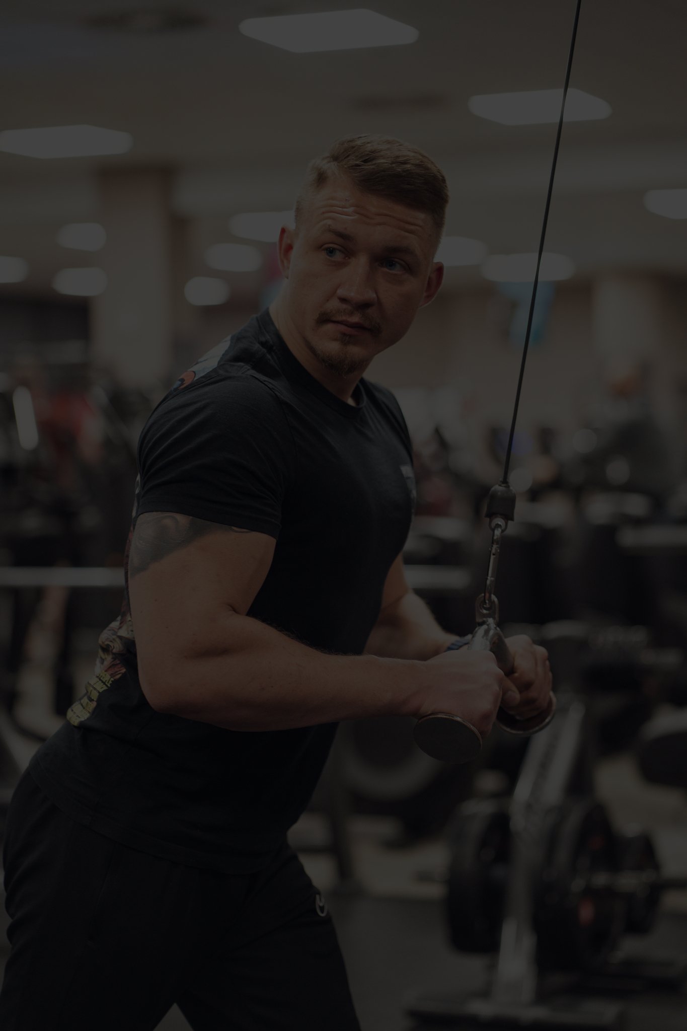 Ein Mann trainiert im Fitnessstudio an einem Kabelzug.
