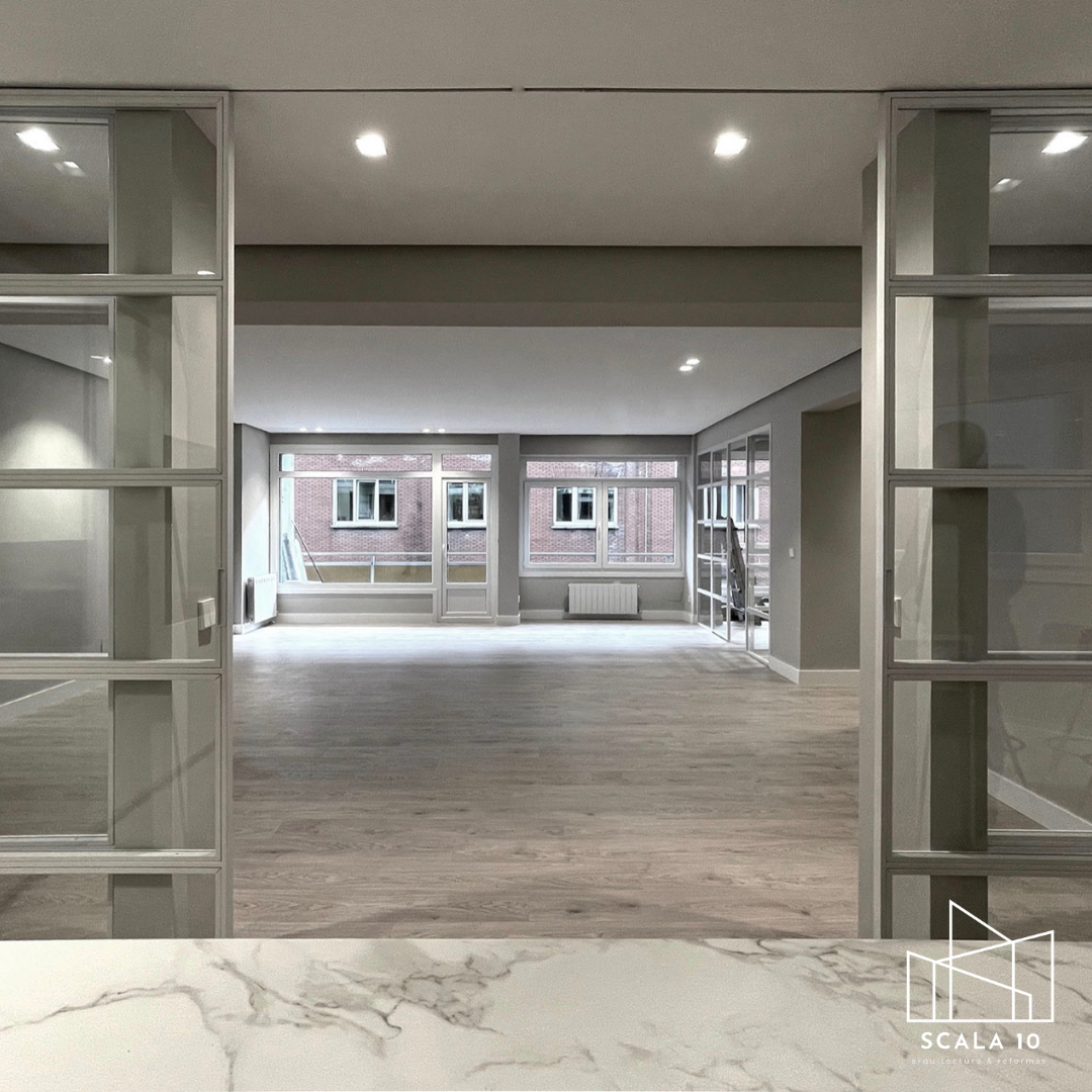 Sala y comedor reformados con iluminación integrada y suelo radiante en Tetuán