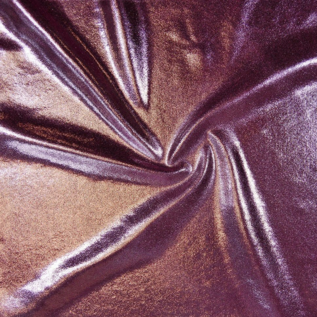 Close-up of shiny, metallic fabric in shades of purple and bronze, twisted into a spiral.