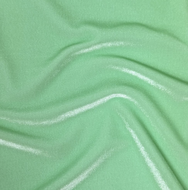 Close-up of green fabric with white wavy lines.