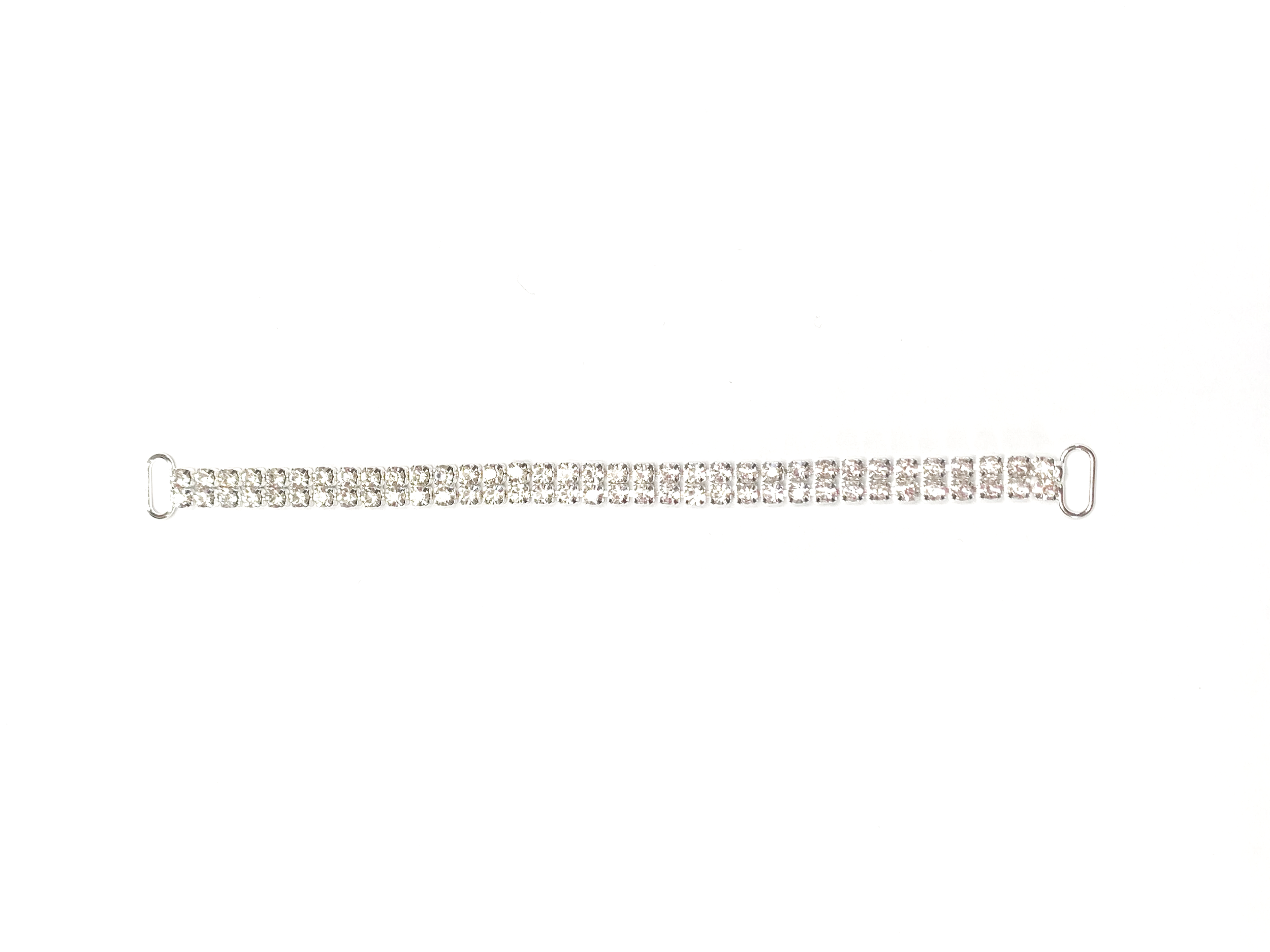 A silver bracelet decorated with numerous small rhinestones, laid flat against a white background.