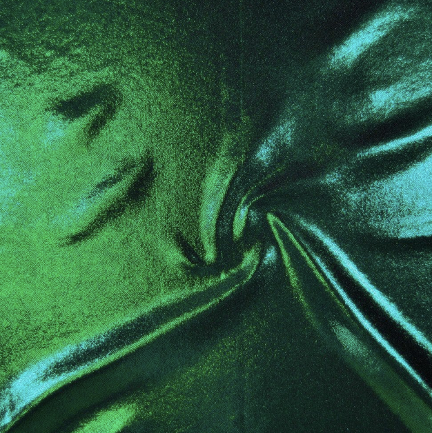 Abstract close-up of synthetic material with green and blue metallic fibers creating a swirling pattern.