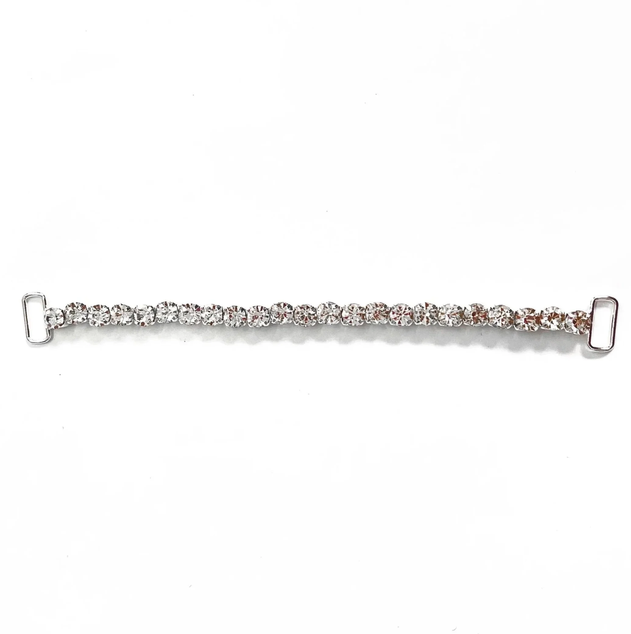 A silver bracelet with multiple clear gemstones, likely diamonds or cubic zirconia, arranged in a line on a white background.