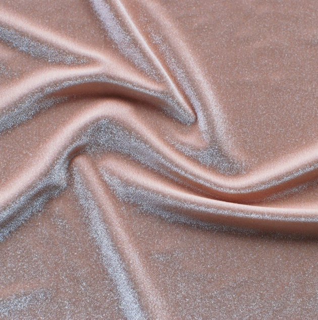 Close-up of pink satin fabric with silver glitter accents, draped with soft folds.